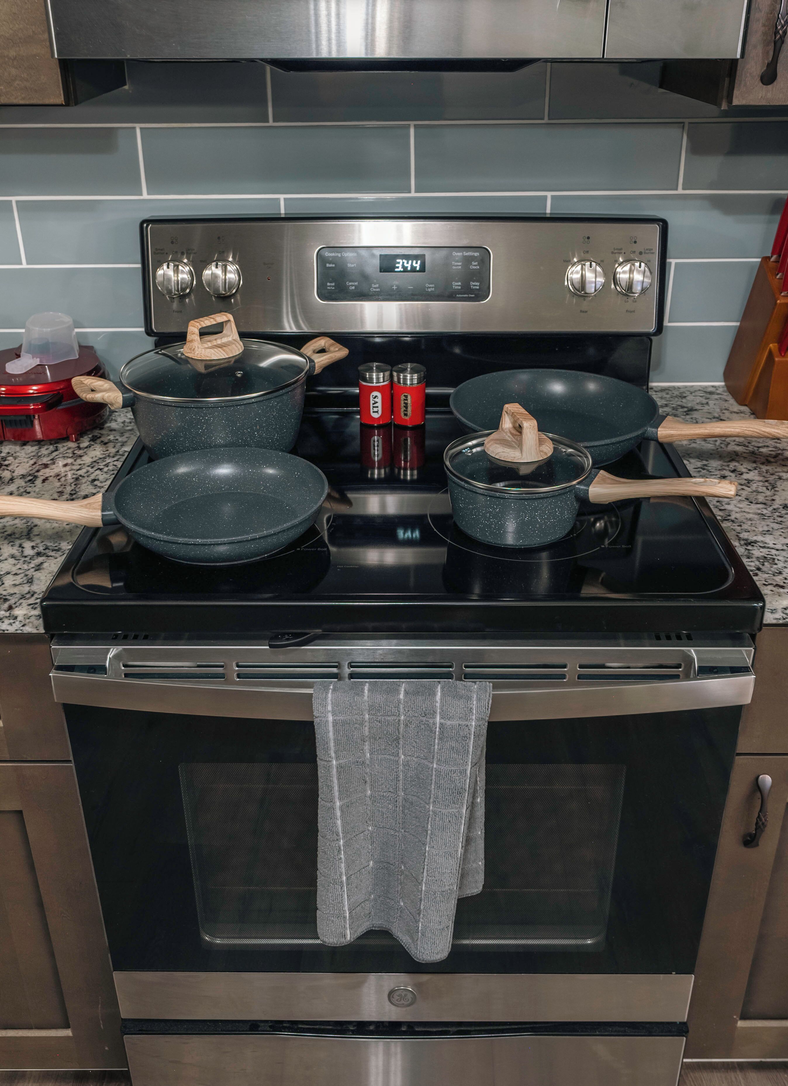 A kitchen with a stainless steel stove, two pots, and a red appliance on the left.