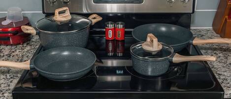 A kitchen with a stainless steel stove, two pots, and a red appliance on the left.