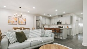 A modern kitchen with white cabinets, a stainless steel refrigerator, and a microwave. - Luxury 3BR in Belle Chasse (Belle Chasse)