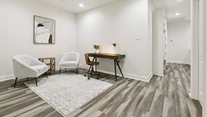 A room with a desk, two chairs, a rug, and a painting on the wall. - Luxury 3BR in Belle Chasse (Belle Chasse)
