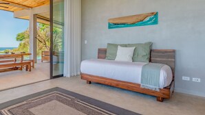 A modern bedroom with a wooden bed, a view of the ocean, and a ceiling fan. - Villa Enlightened/Ocean View/Walk to Beach (Nosara)