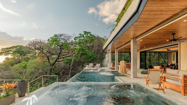 A modern outdoor pool area with lounge chairs and a waterfall feature. - Villa Enlightened/Ocean View/Walk to Beach (Nosara)