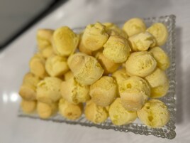 Una bandeja de vidrio con pequeños pasteles redondos y amarillos.