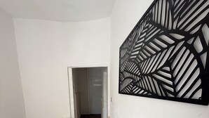 Um corredor com corrimão branco, decoração de parede estampada e piso coberto por carpete.