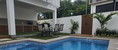 Een buitenzwembad, parasols bij het zwembad en ligstoelen