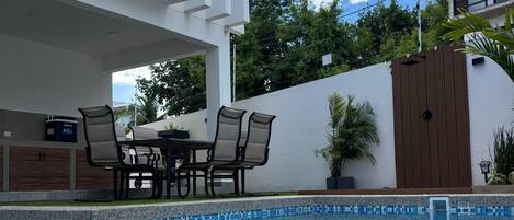 Alberca al aire libre, sombrillas en la alberca y camastros