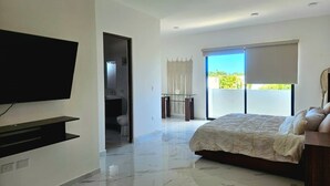 Un dormitorio moderno con una cama grande, un televisor y un balcón con vistas.