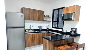 Una cocina moderna con refrigerador, microondas y cafetera.