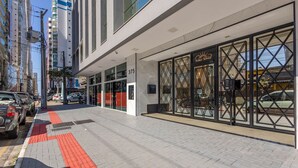 Un edificio moderno con fachada de vidrio, una entrada destacada con una reja de metal negro y un letrero que dice "Solar Tower".