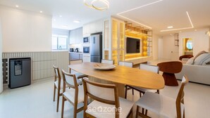 Una cocina moderna con comedor, electrodomésticos integrados y una lámpara de diseño.