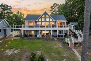 A large, two-story house with a covered porch, a staircase, and a well-maintained lawn. - Lakefront, Hot Tub, Kayaks, Pool Table & Fire Pit (Henrico)