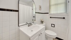Ein Badezimmer mit einem weißen Waschbecken, Spiegel und WC.