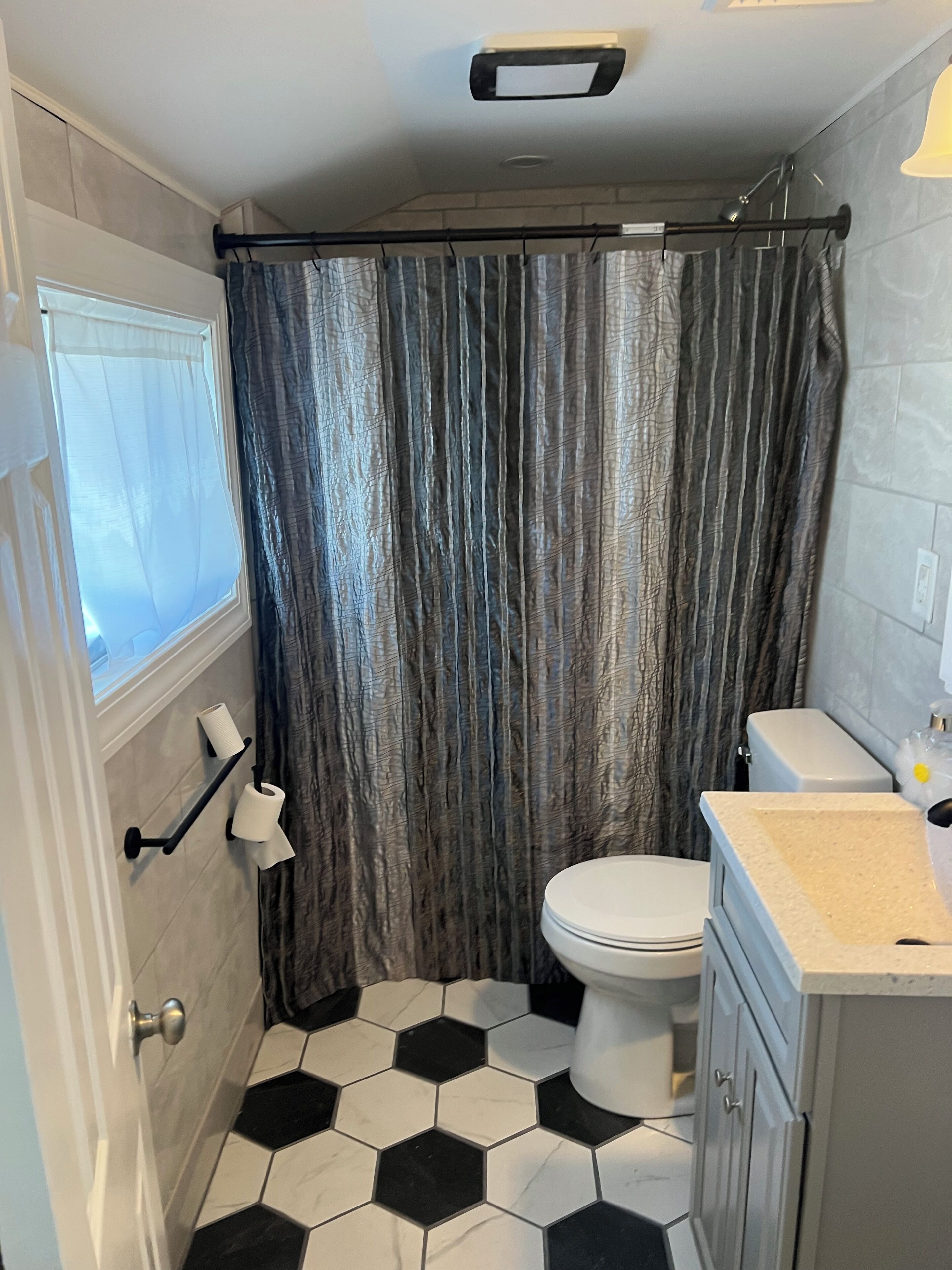 Une salle de bain avec des toilettes, un lavabo et un rideau de douche.