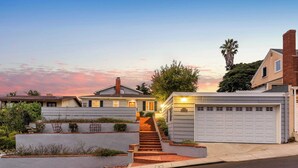 A residential street with houses, a driveway, and a staircase leading to a garage. - Point Loma Home w/ Putting Green, Firepit + Game Room & Beach Access Zola Street by Avantstay (San Diego)