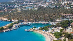 Un pueblo costero con puerto deportivo, playa y edificios residenciales.