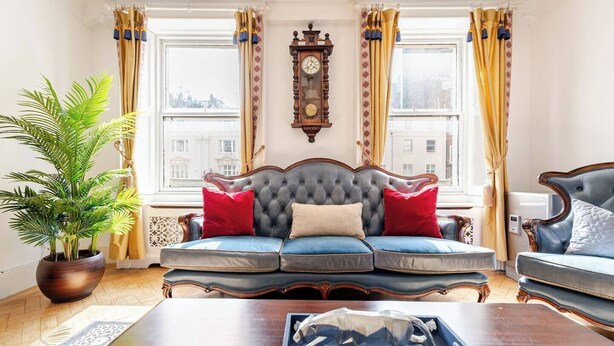 A traditional living room with a sofa, a coffee table, and a potted plant. - The Belgravia Townhouse — Grand 8‑Guest Home (London)