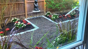 A garden with a statue, a wooden fence, and various plants. - Islesboro Suite in the Inn at Starlight Lodge (Maine)