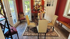 A dining area with a wooden ceiling, red walls, and a central table with chairs. - Islesboro Suite in the Inn at Starlight Lodge (Maine)