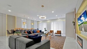 Een moderne woonkamer met een hoekbank, een salontafel en een aan de muur bevestigde televisie.