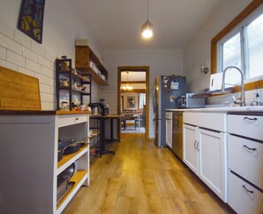 A kitchen with white cabinets, a wooden countertop, and a view into the dining area.