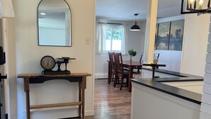 A spacious kitchen with wooden flooring, a central island, and a dining area with a table and chairs. - Spacious 4-bedroom house in charming Ephrata (Ephrata)
