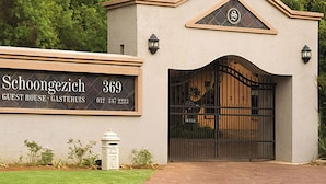 Ein Gästehaus mit einem Schild, auf dem steht: "Schoongezich 369 GUEST HOUSE GASTERUIS 012 347 2233".