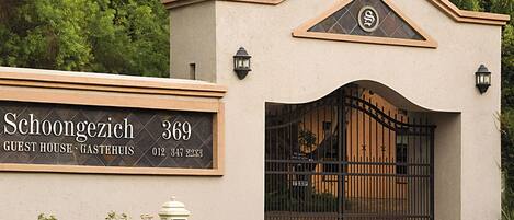 Una casa de huéspedes con un letrero que dice "Schoongezich 369 GUEST HOUSE GASTERUIS 012 347 2233".