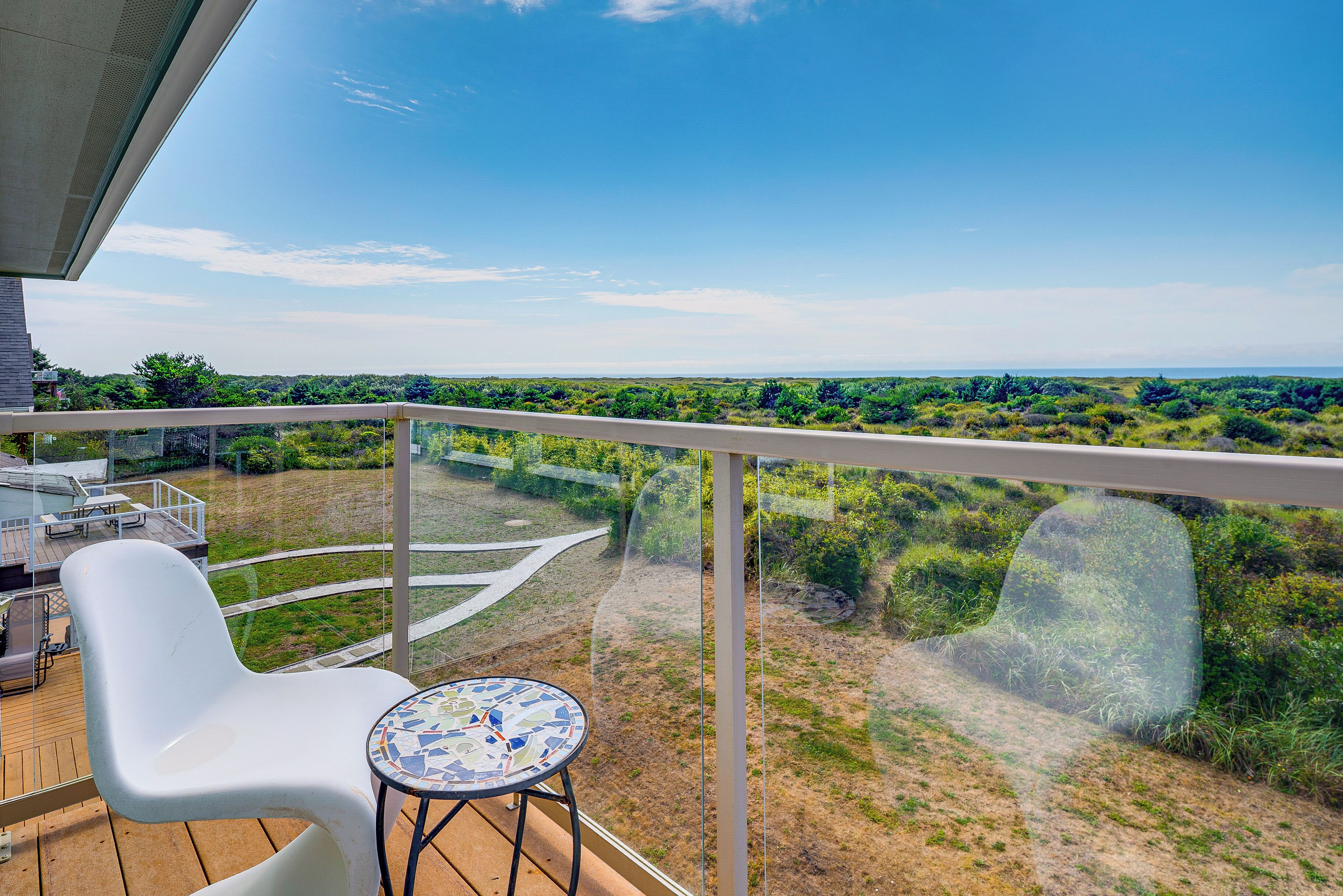Ein Balkon mit Blick auf eine grüne Landschaft und einen klaren Himmel.
