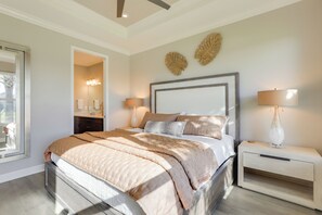 Une chambre à coucher moderne avec un grand lit, des tables de chevet et des œuvres d’art décoratives au mur.