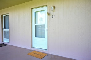 A building with two doors, each marked with the number 21, and a welcome mat at the entrance.