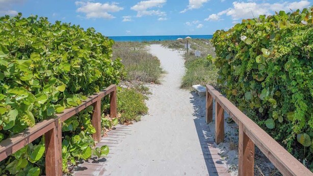 A pathway leading to a beach with wooden railings on both sides. - Steps to Sand! Ground-Floor 2BR by Pool (Cocoa Beach)