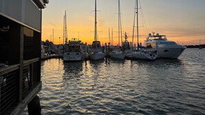 Un puerto deportivo con varios yates amarrados al atardecer.