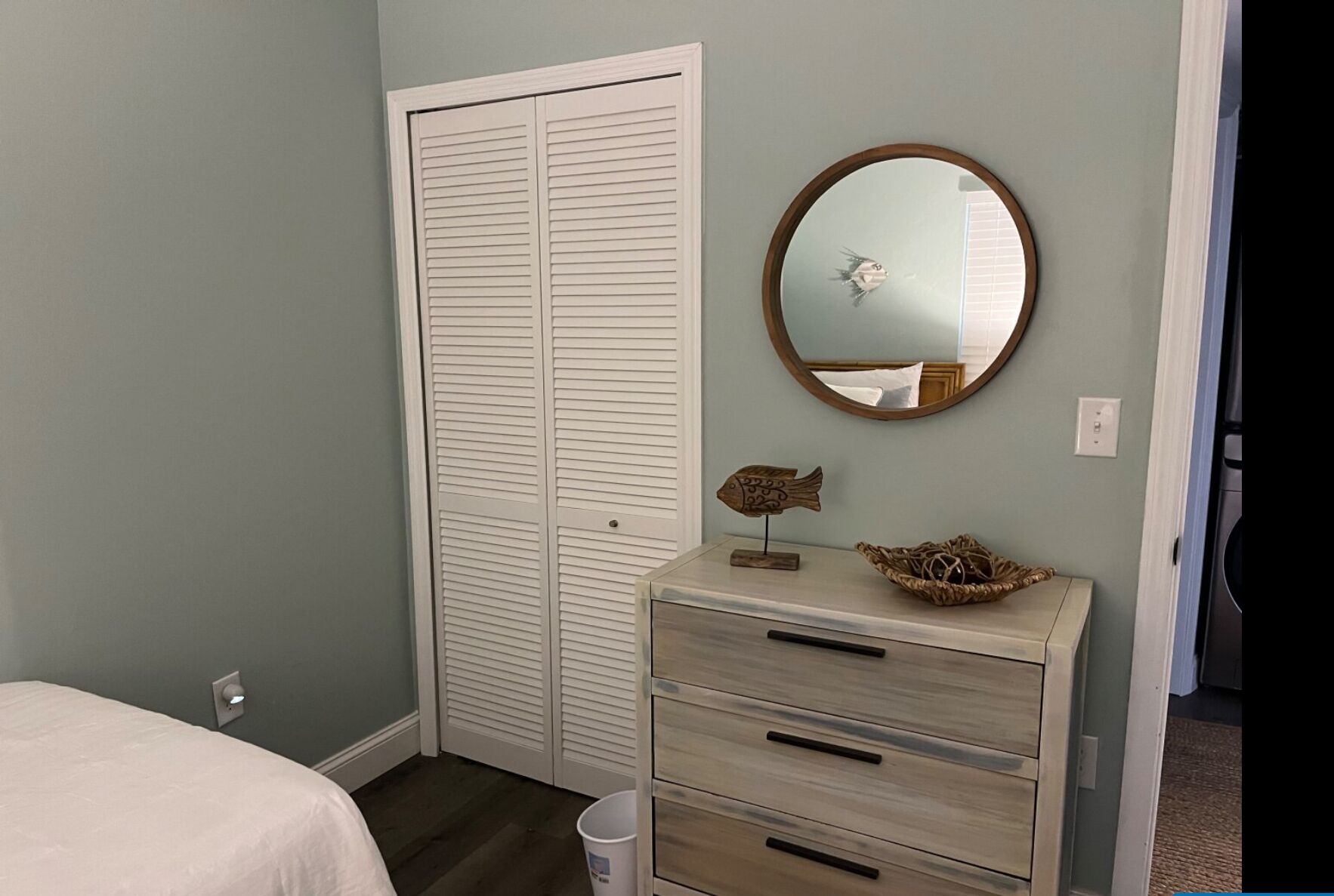 A bedroom with a bed, a dresser, a mirror, and a closet.