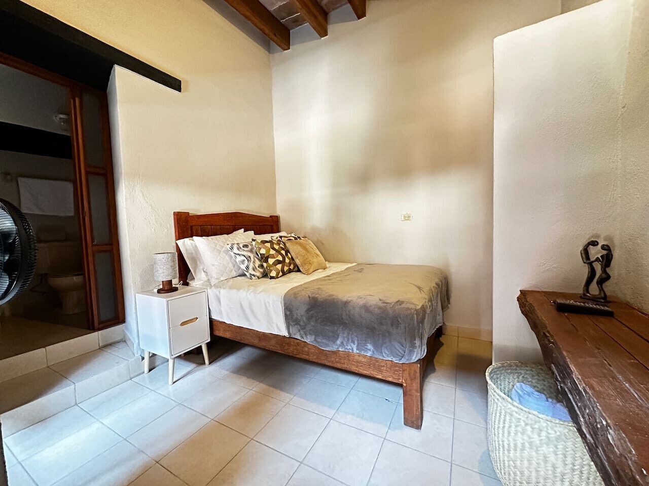 Une chambre à coucher avec un lit, une table de chevet et un banc en bois.