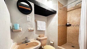 A bathroom with a sink, toilet, and shower. - Hotel Room, one block from the Lake centr 3 (Valle de Bravo)
