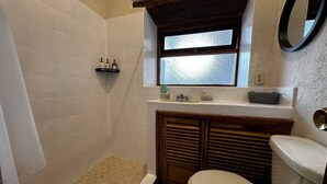 A compact bathroom with a shower, toilet, and a small window above the sink. - Hotel type room, one block from the Lake centr 5 (Valle de Bravo)