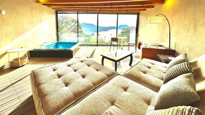 Une pièce spacieuse avec un grand canapé, une petite table et un espace piscine.