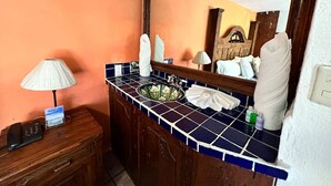 A bathroom with a wooden vanity, a sink with a decorative basin, a mirror, and a towel rack. - Vista Rio Bosque Apartment, Heated Pool 6 (Valle de Bravo)