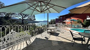 An outdoor patio with a pool, tables, and umbrellas. - Jacuzzi Apartment Lake View, Heated Pool 7 (Valle de Bravo)