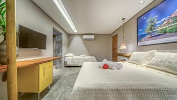 A modern hotel room with a bed, a television, a desk, and a large window.