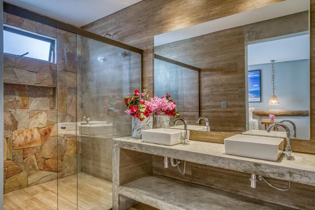 Ein modernes Badezimmer mit Duschkabine aus Glas, Marmorplatte und großem Spiegel.