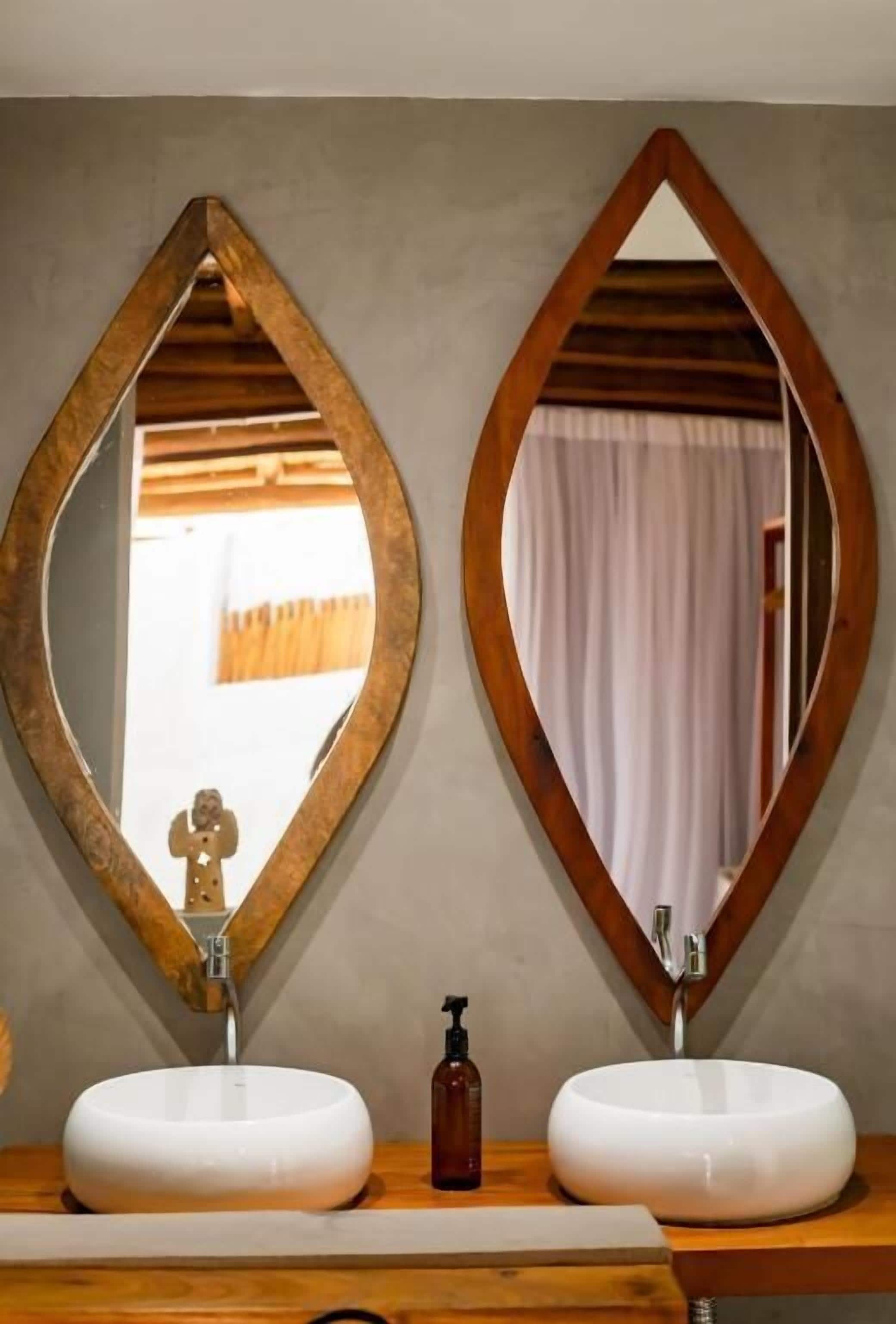A bathroom with two sinks, each with a mirror above.