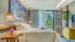 A hotel room with a large bed, a wooden headboard, a small table with a vase, a television, and a balcony with a view of palm trees.