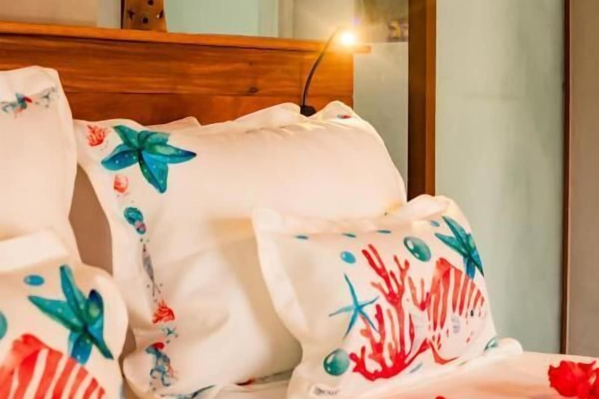 A bed with decorative pillows and a wooden headboard.