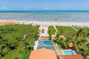 Un resort con piscina, acceso a la playa y vista al océano.