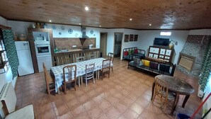 A spacious kitchen with a dining area, a small table, and a TV.