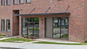 Un edificio moderno de ladrillo con ventanas amplias y un acceso cubierto.