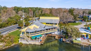 A riverside restaurant with outdoor seating and a dock. - Wet Feet Retreat Waterfront-Manatees, Kayaks, SUPs (Spring Hill)