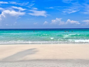 A beach with clear turquoise water and a sandy shore.