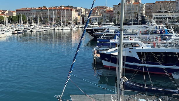 A marina with multiple boats docked, a prominent building with a dome in the background, and a clear blue sky. - Right in the town center, 5m from the beach on foot and 2m from the SNCF train station (Saint-Raphaël)